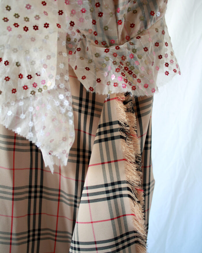 Detail of the combination of two fabrics, plaid check nova fabric and floral embroidered sheer fabric