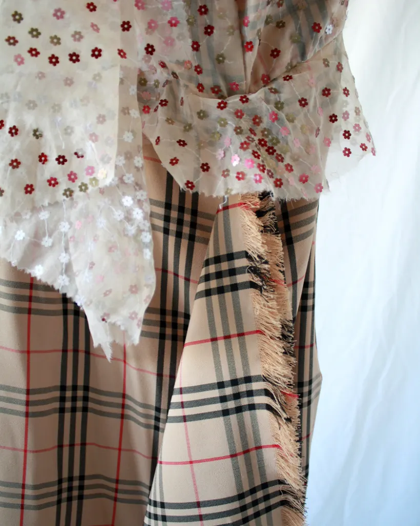 Detail of the combination of two fabrics, plaid check nova fabric and floral embroidered sheer fabric