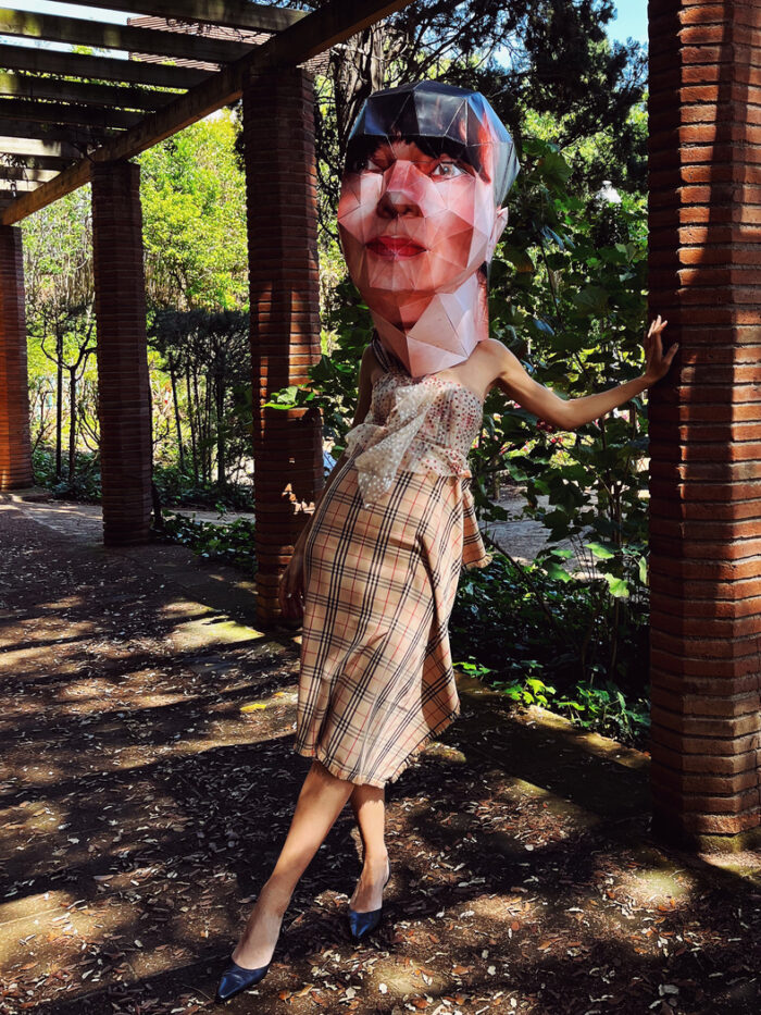 Plaid ruffle dress with Big Head paper mask in Montjuic Barcelona
