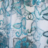 Close up of the sheer sequined blue skirt of a tapestry bustier gown