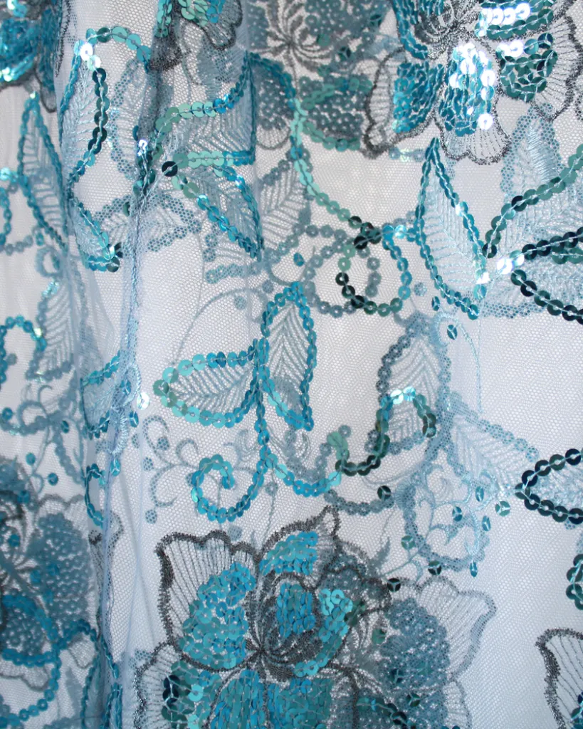 Close up of the sheer sequined blue skirt of a tapestry bustier gown