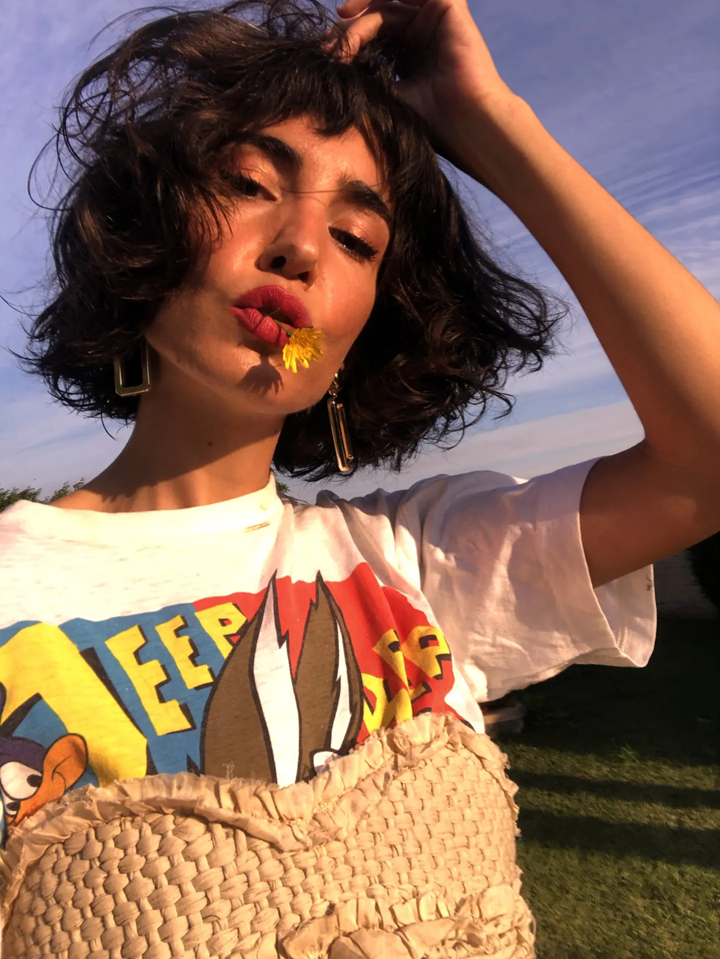 Amai Rodríguez, outdoors, wearing a reworked cartoon-print tee over a ruched corset top.